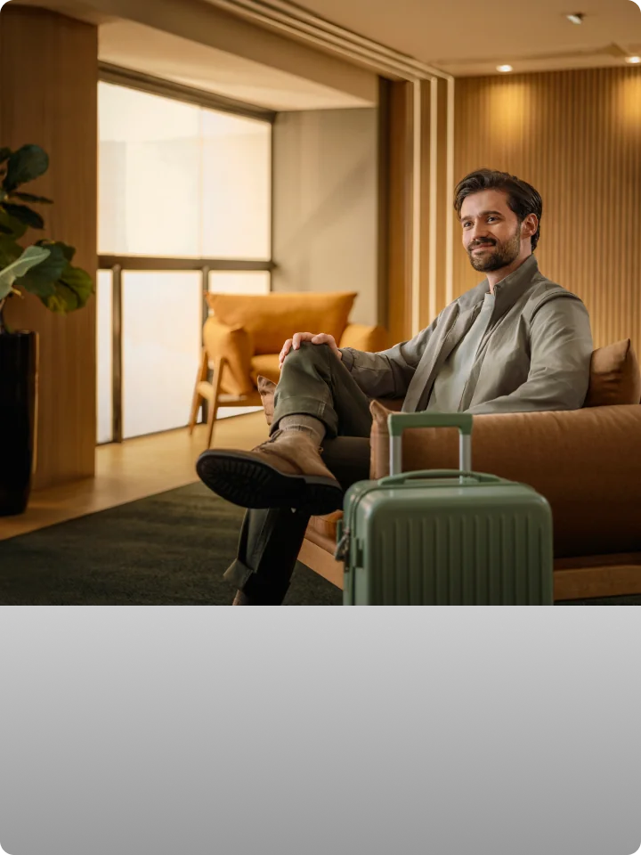 Homem aguardando em sala VIP de aeroporto.